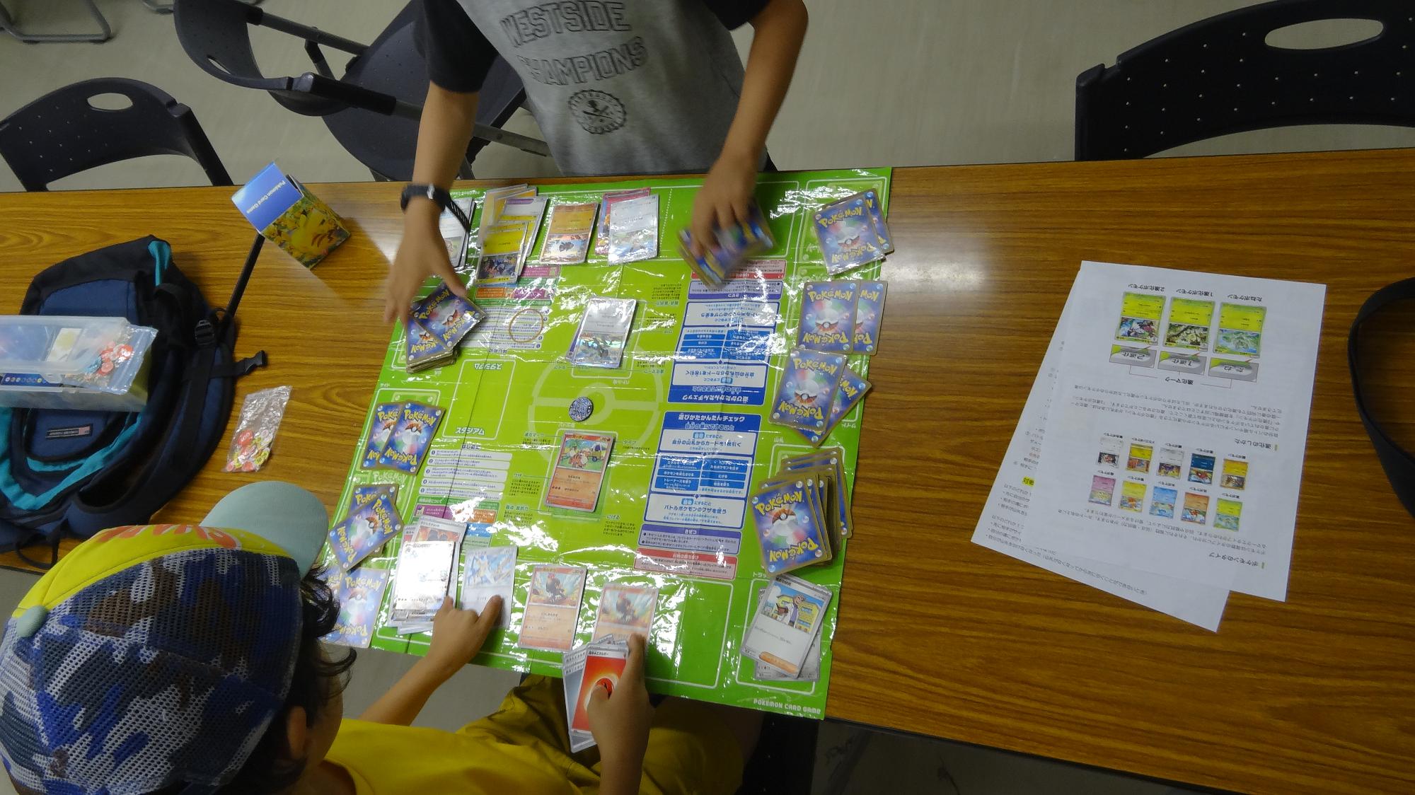 子どもがポケモンカードを使用して相手と対戦する様子