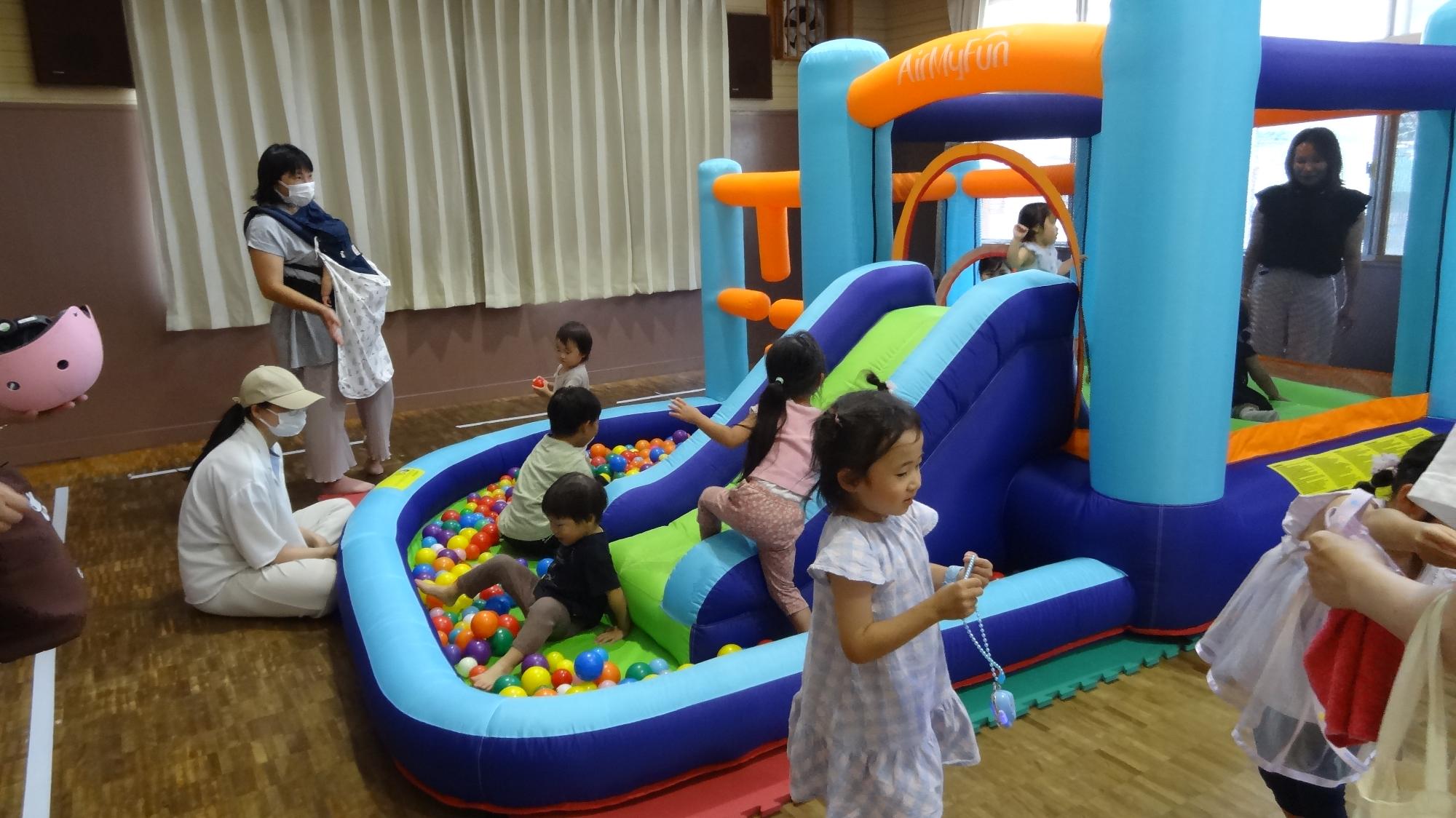 ジャンピングスライダーで多くの子どもが遊んでいる様子