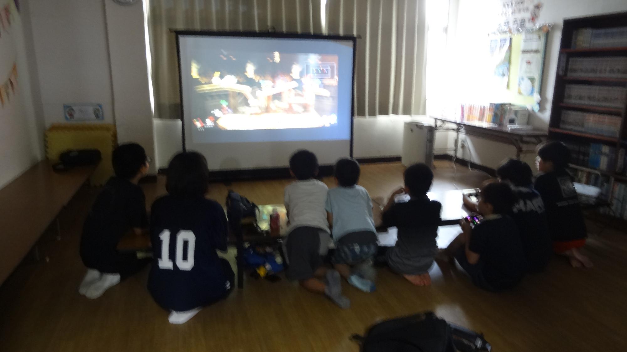 プロジェクターの前で子どもがゲームをする様子