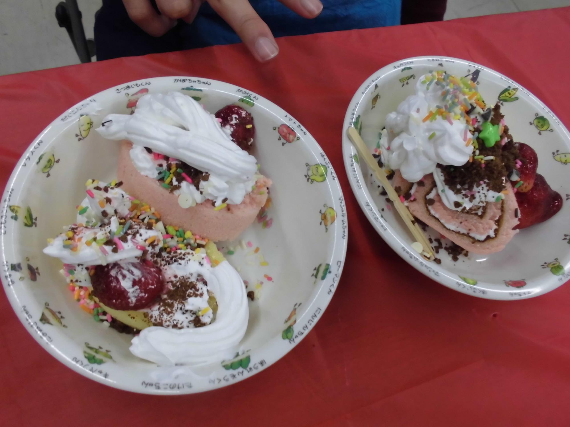 ホイップクリームやチョコレートでデコレーションされたロールケーキ2つ