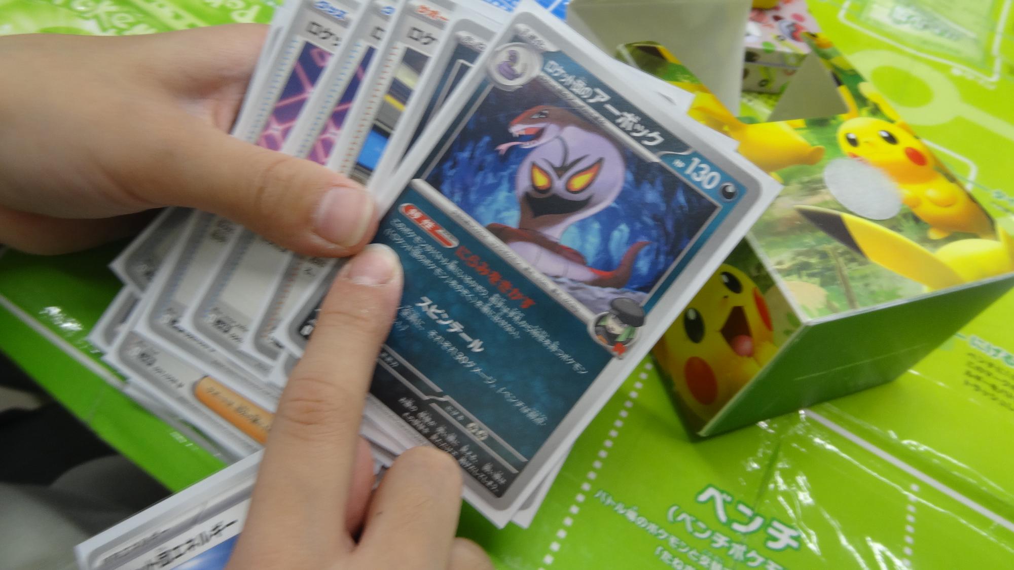 ポケモンカード対戦中、プレイヤーがカードを指さしながら特性について説明をしている様子