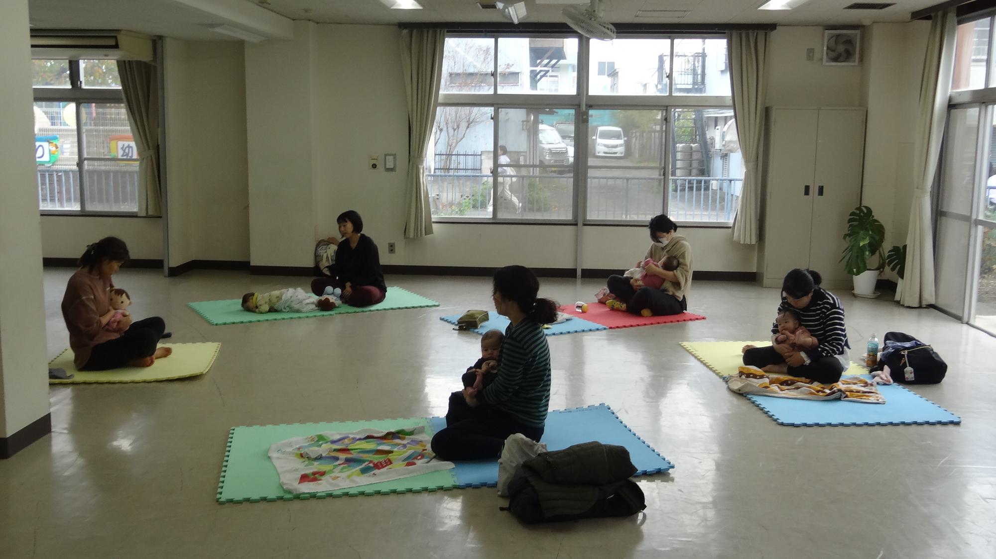 一番左に先生がいて、4組の親子さんがそれを見ながらヨガを教わっている様子