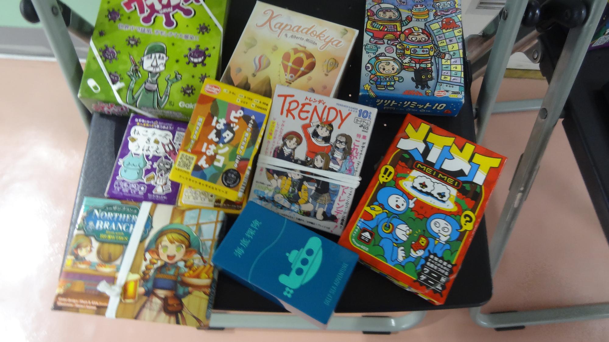 たくさんのボードゲームが椅子の上に並べられている様子の画像