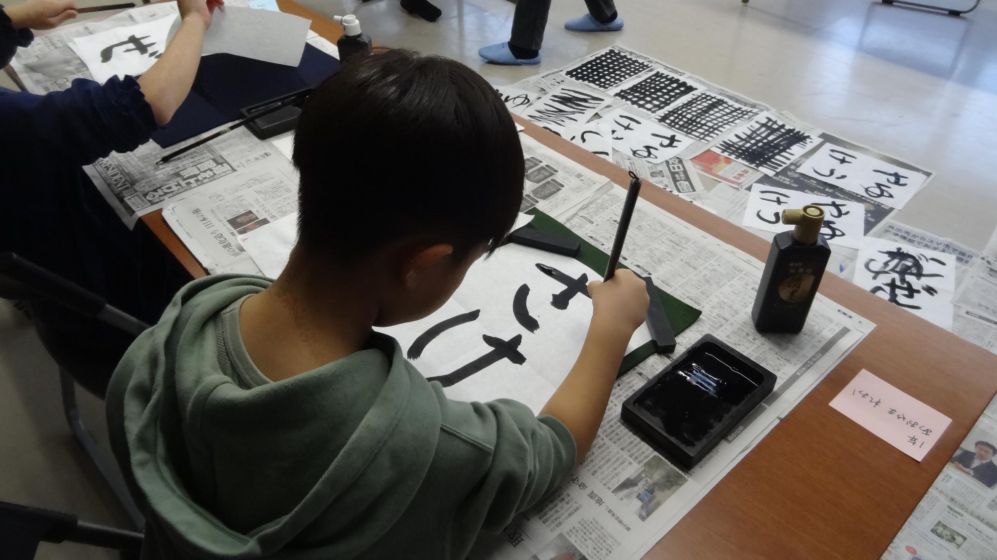 小学生がさけという字を習字で書いている様子