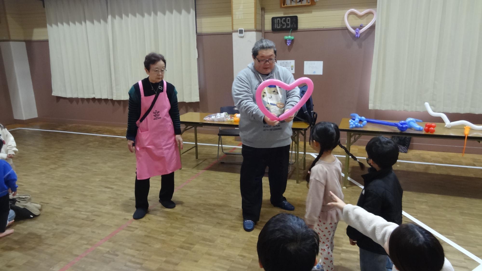 ピンク色のハートのバルーンをプレゼントしている様子