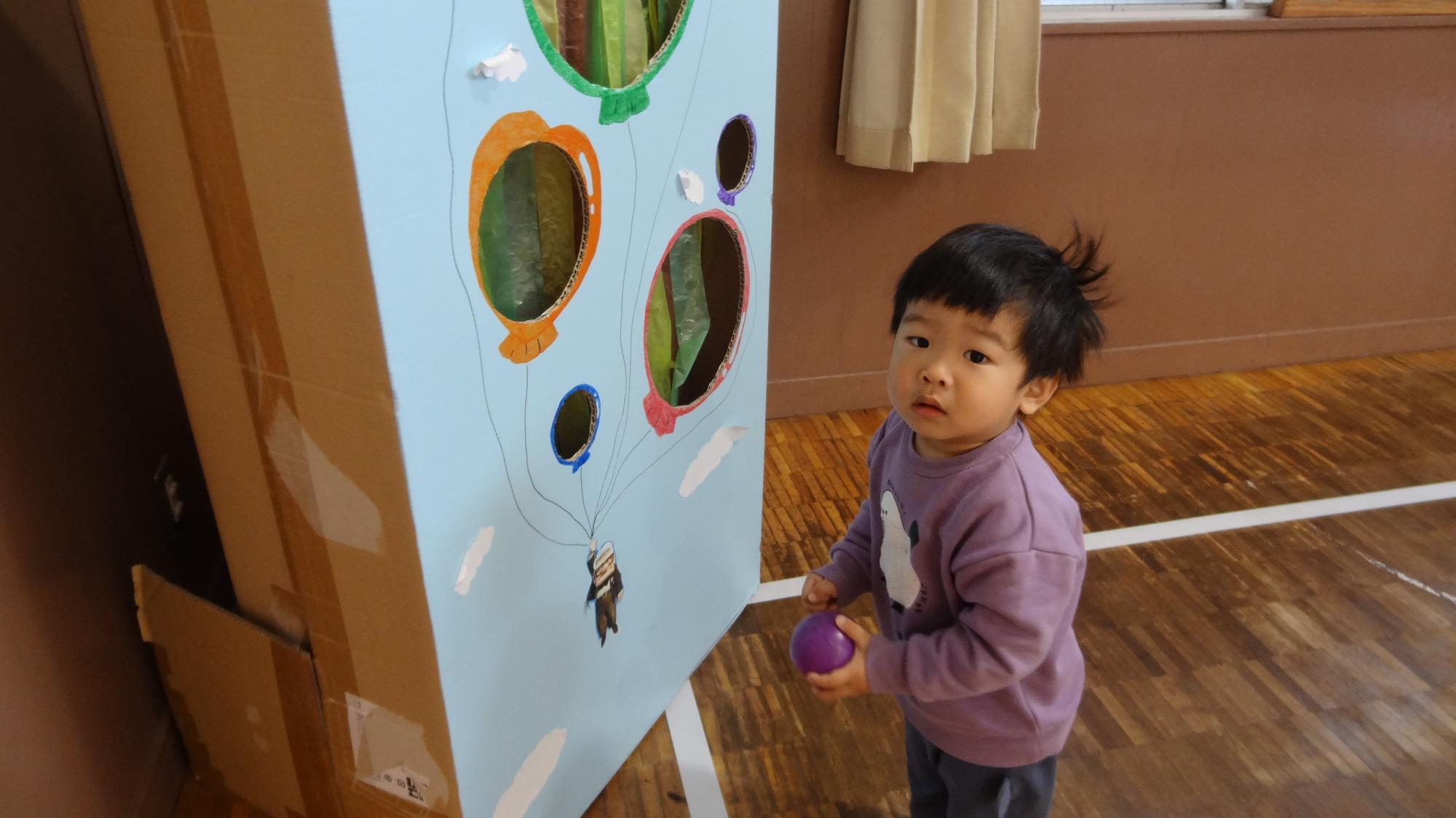 幼児が段ボールで作成された遊戯で遊んでいる際に、こちらを見たときの写真