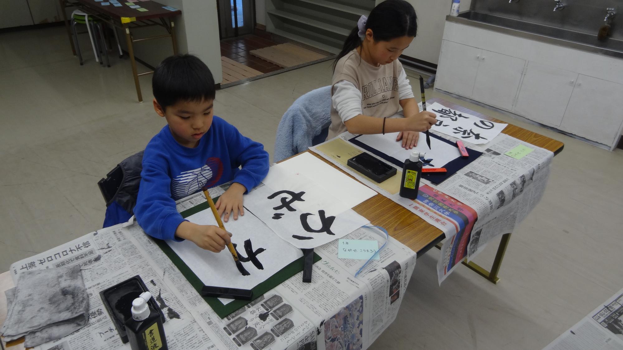小学生二人が書道をしている様子