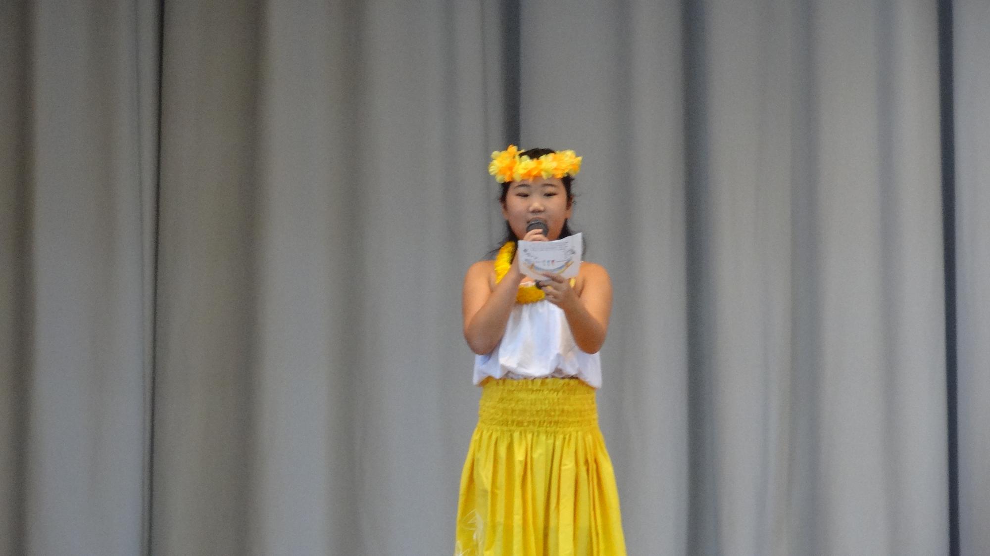 小学生がフラダンス発表の際、司会をしている様子