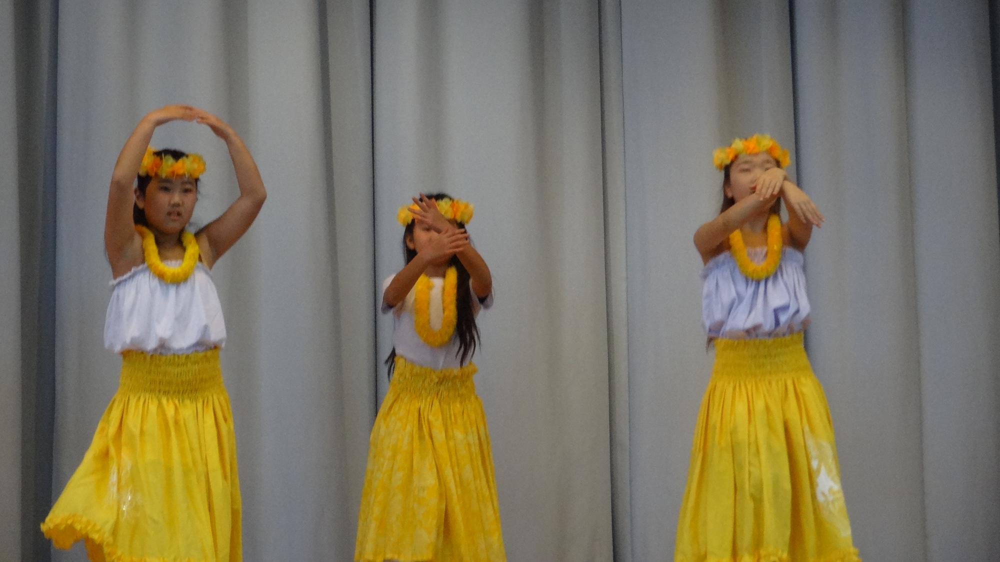 小学生3名がフラダンスをしている様子