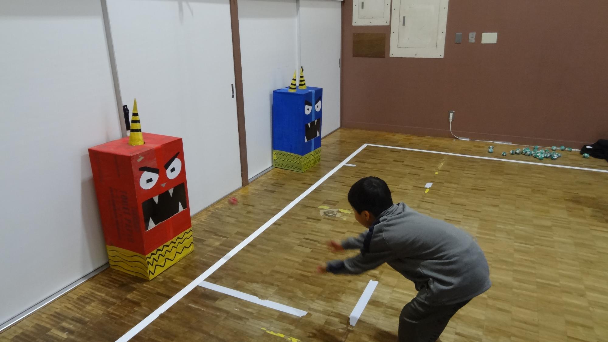 鬼の口に向かって玉を投げている様子