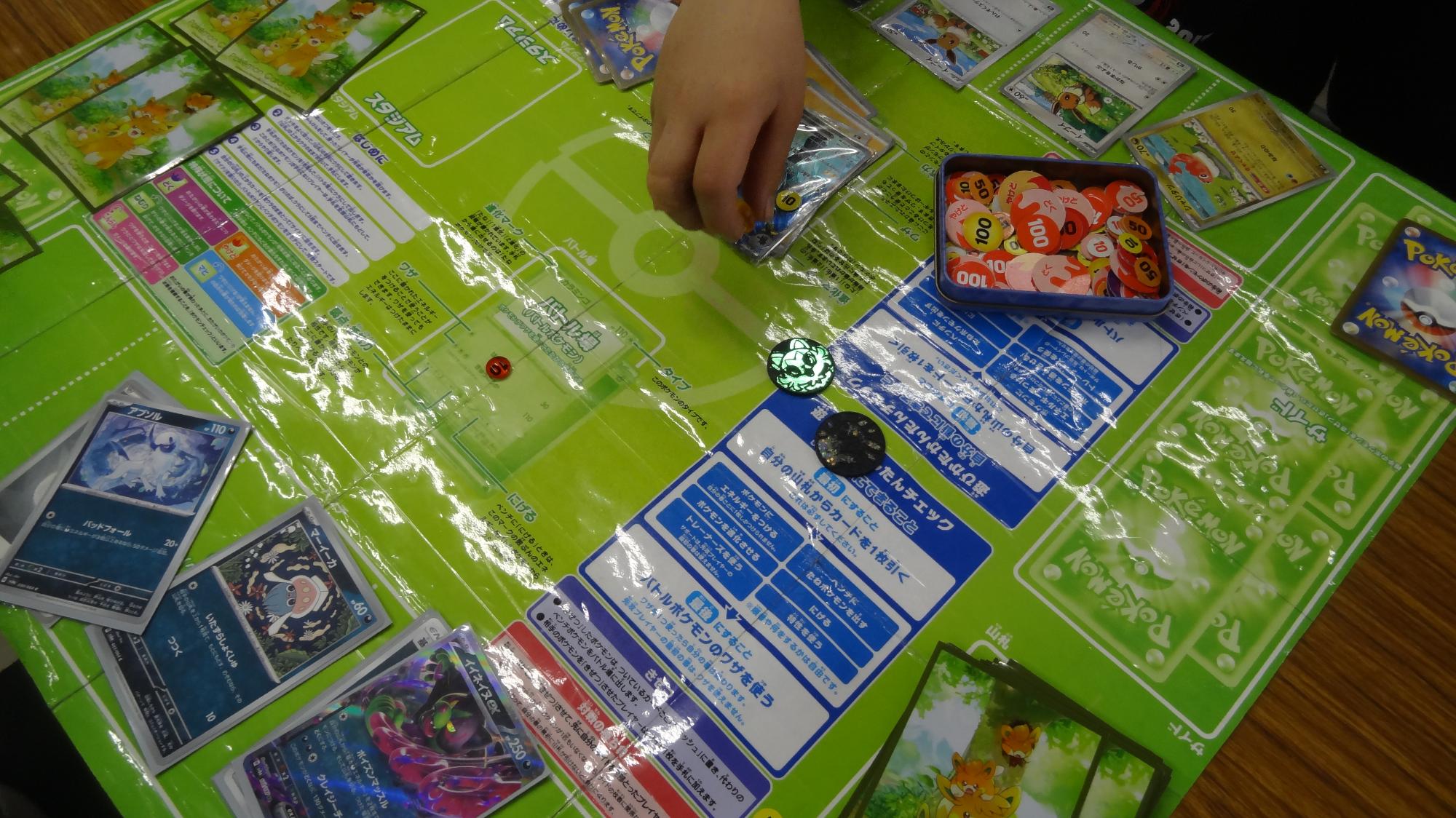 机にポケモンカードを広げている様子。
