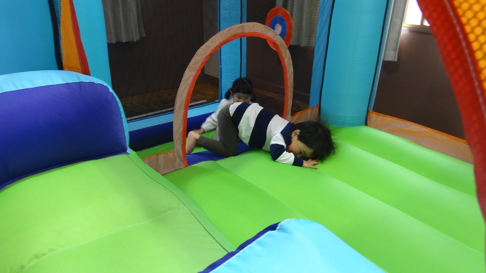 幼児二人がジャンピングスライダーで遊んでいる様子