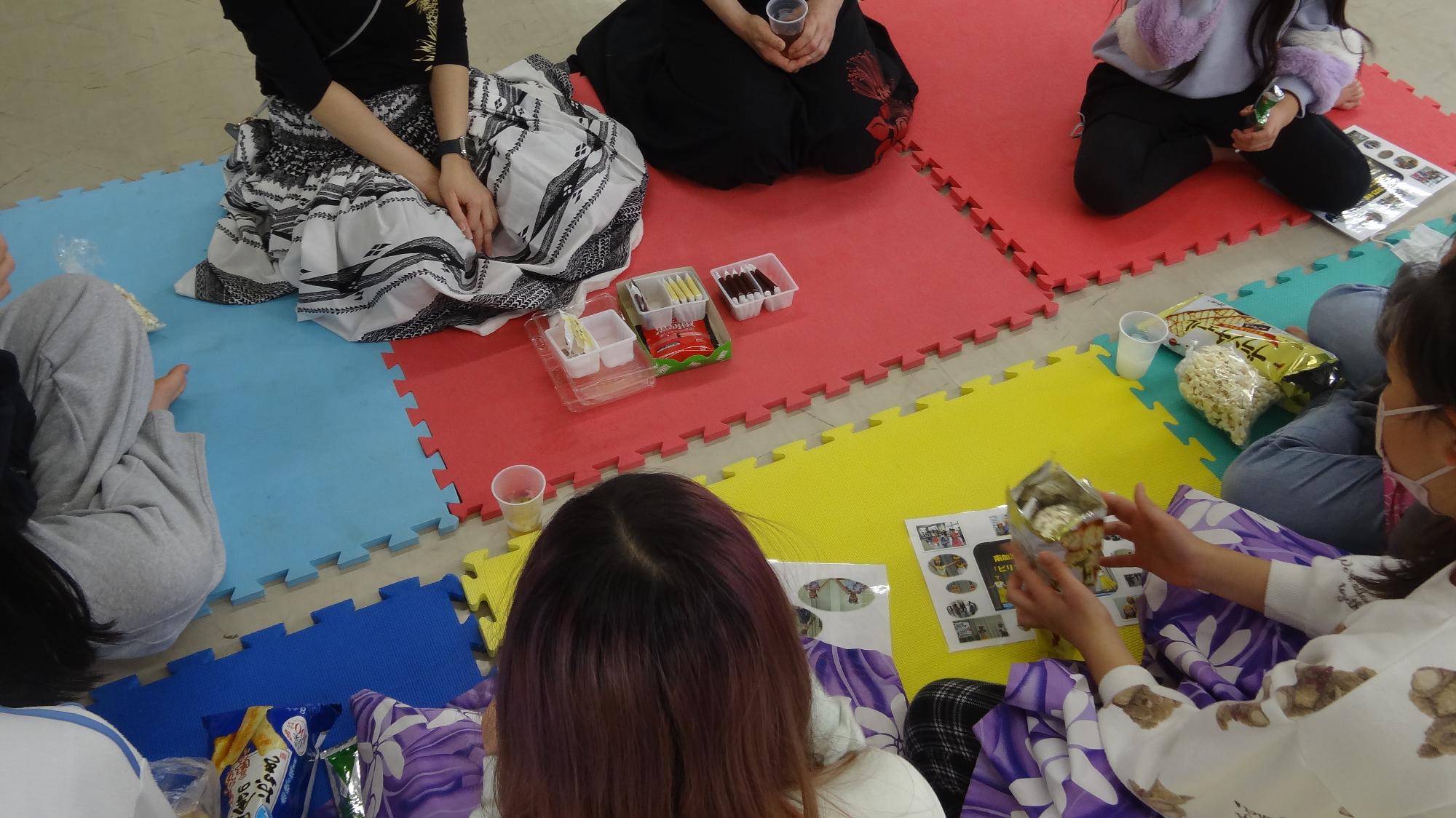 輪になってお菓子を食べてくつろいでいる様子