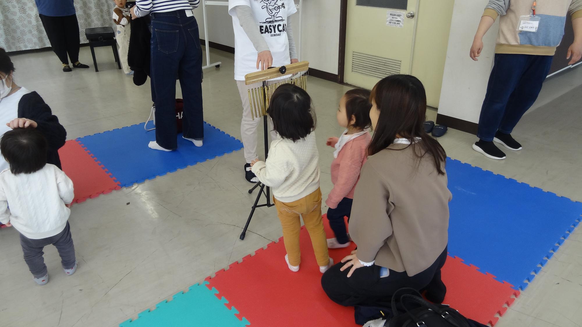 幼児がウィンドチャイムを鳴らしている様子