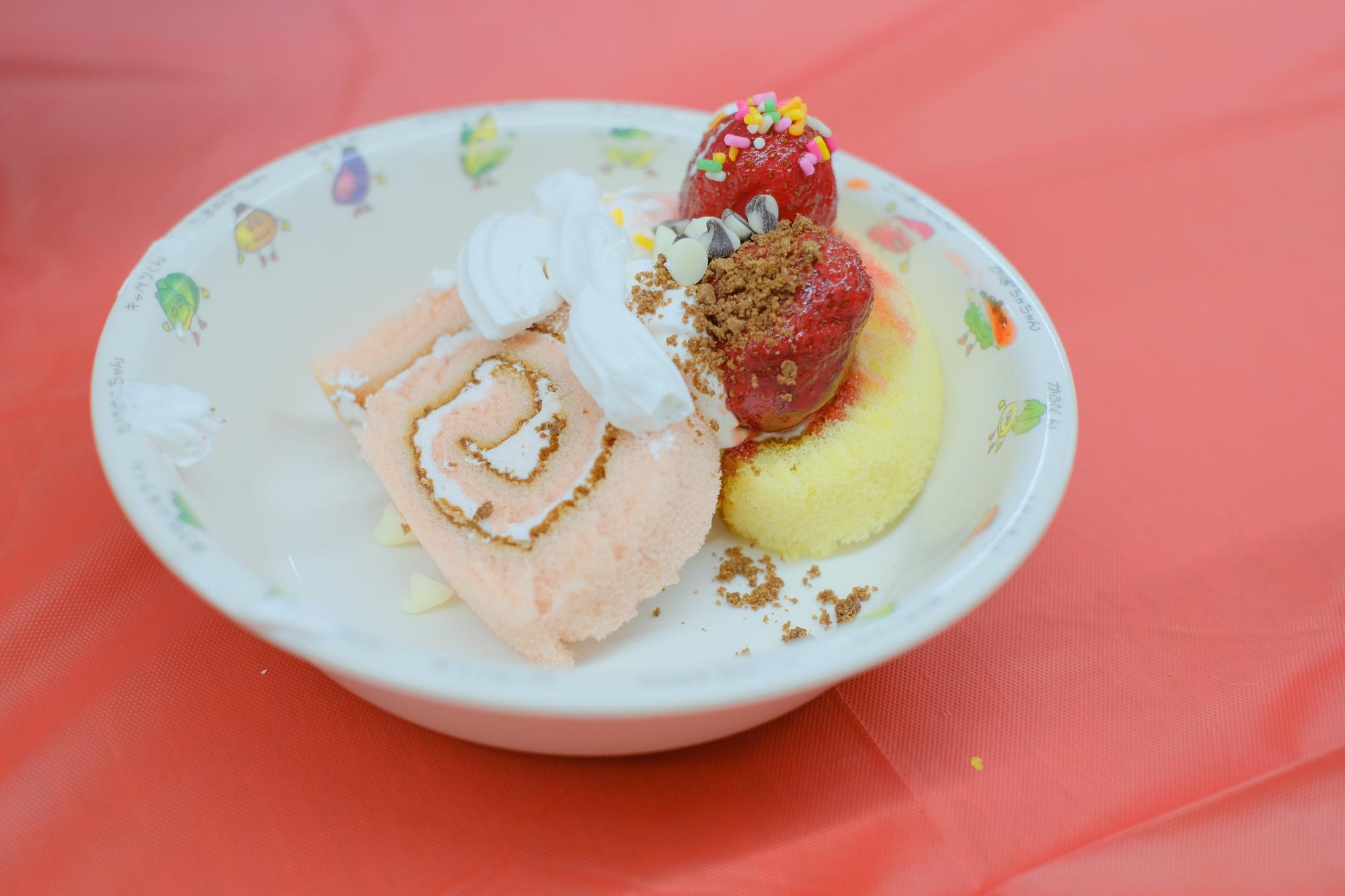 ホイップクリームやチョコレートでデコレーションされたロールケーキの写真