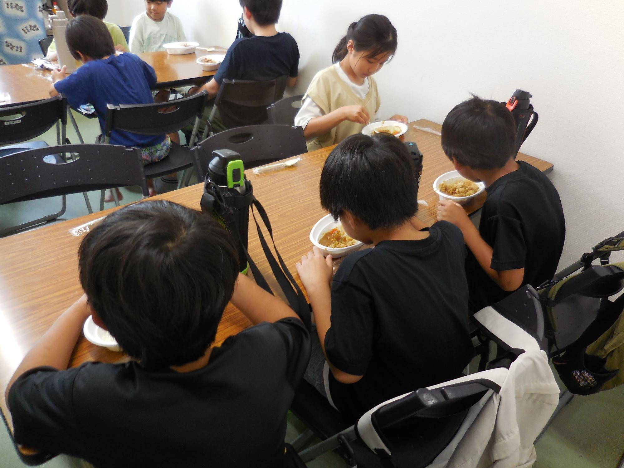 子どもたちがカレーを食べている様子。