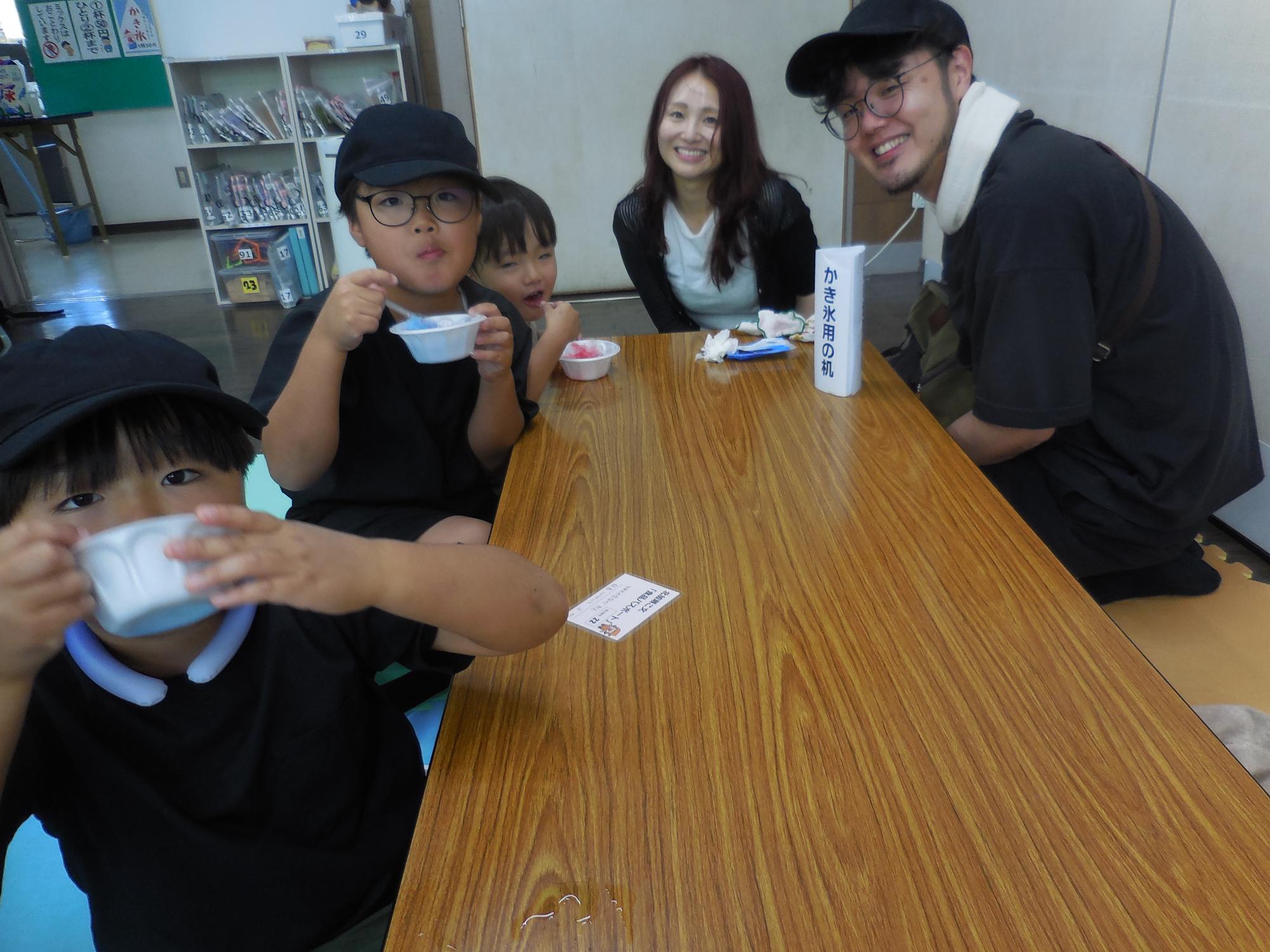 かき氷を食べる家族の様子。