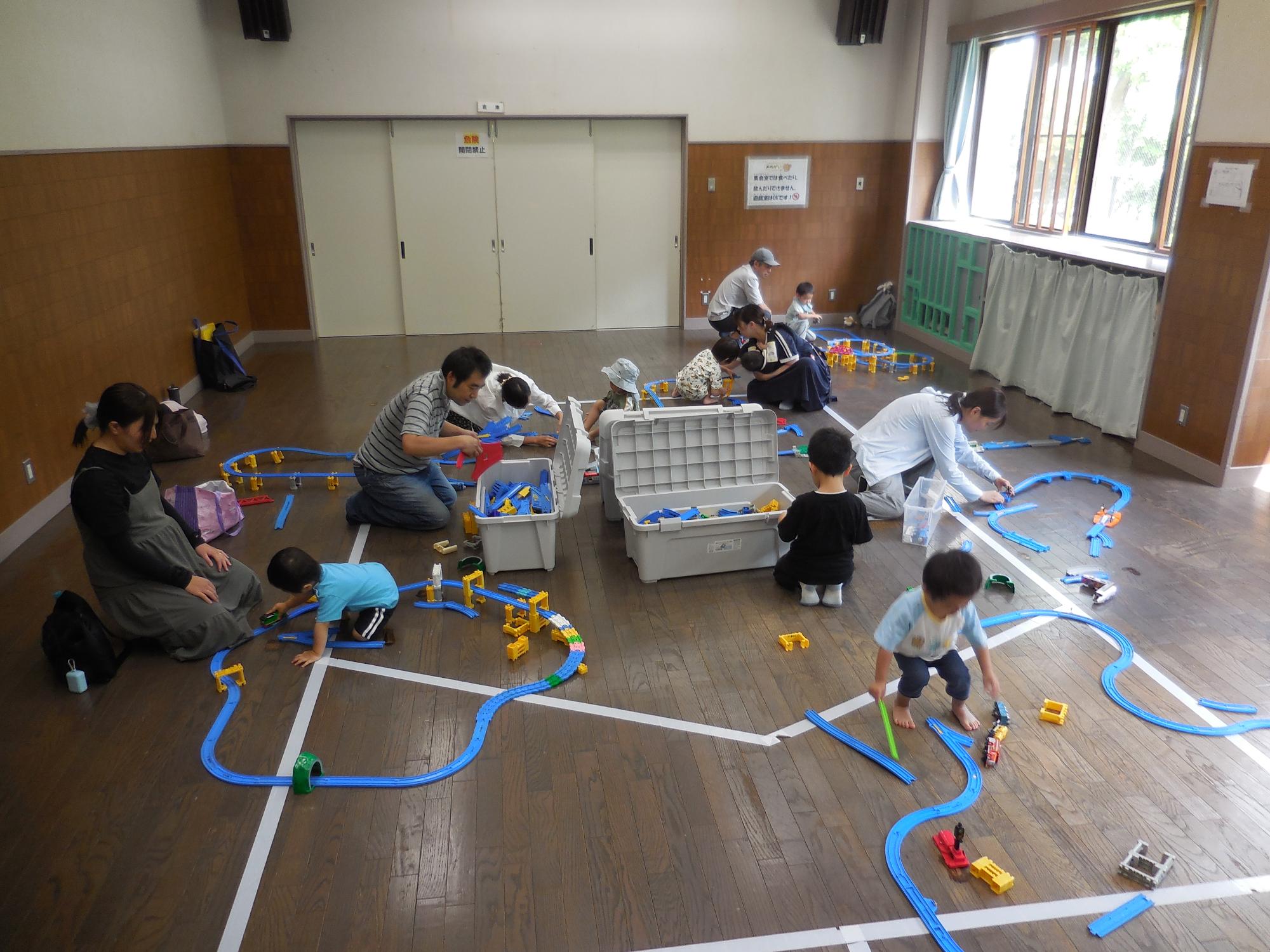 親子でプラレールを楽しんでいる様子の写真