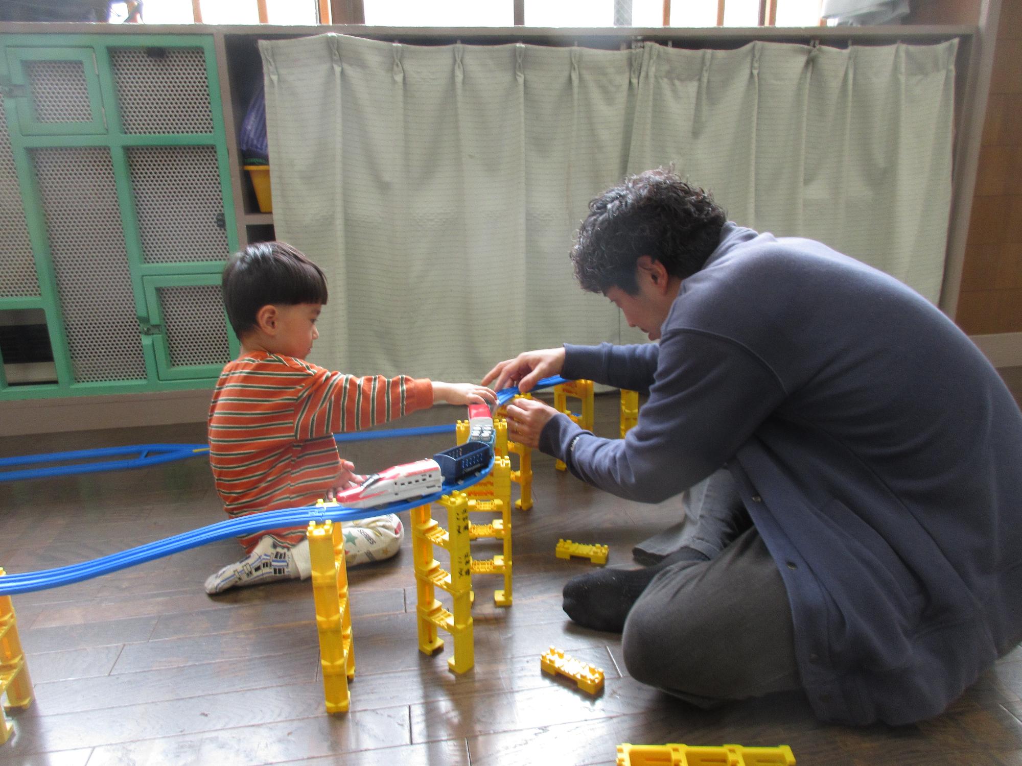 親子でプラレールを組み立てている様子