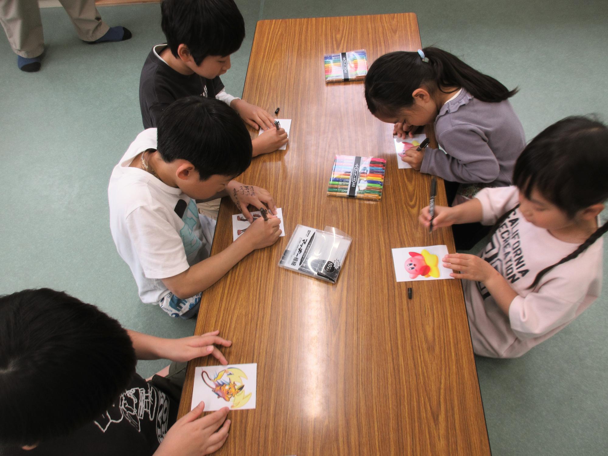 子どもたちがプラバンに絵を描いている様子