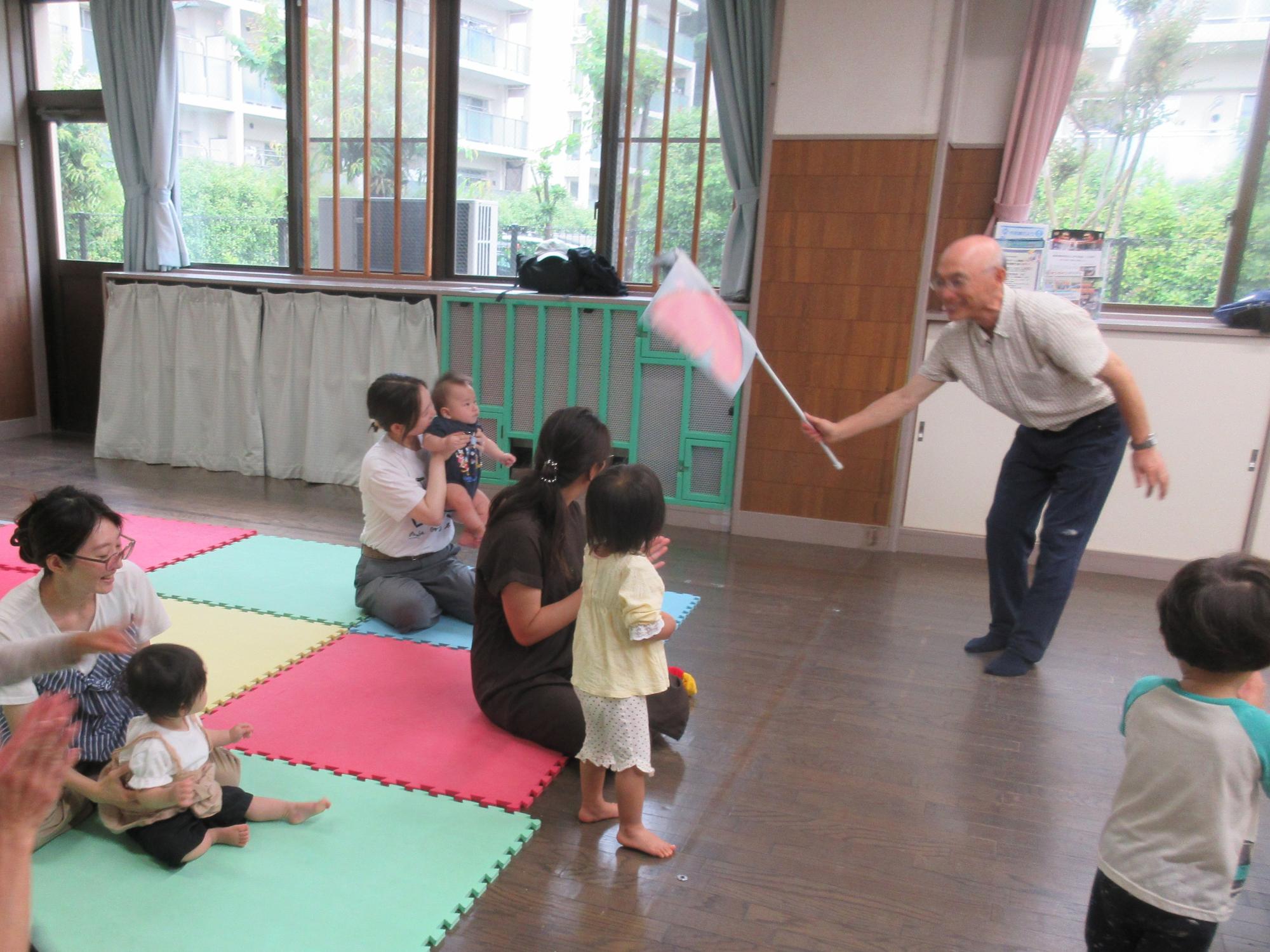 はらぺこあおむしの蝶々を模した旗を使って、子どもたちを喜ばせている様子。