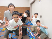 完成したコースの前でピースサインをして記念撮影している6人の男の子たちの写真