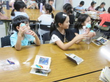 作った作品を手に持ちニコニコしている3人子供たちの写真