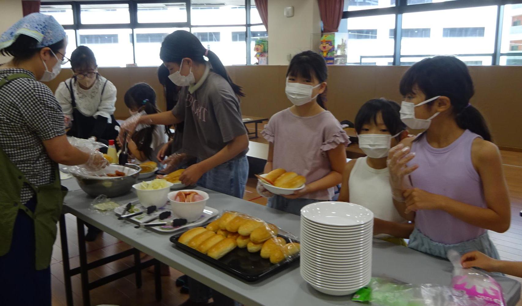 こすぎカフェでパンに具材を入れている様子