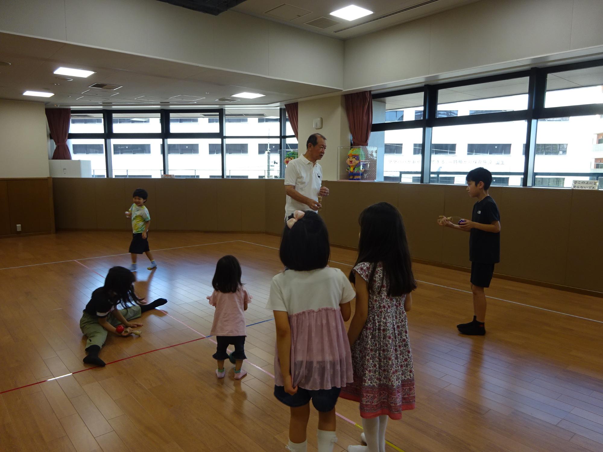 けん玉講師に技を教わっている様子