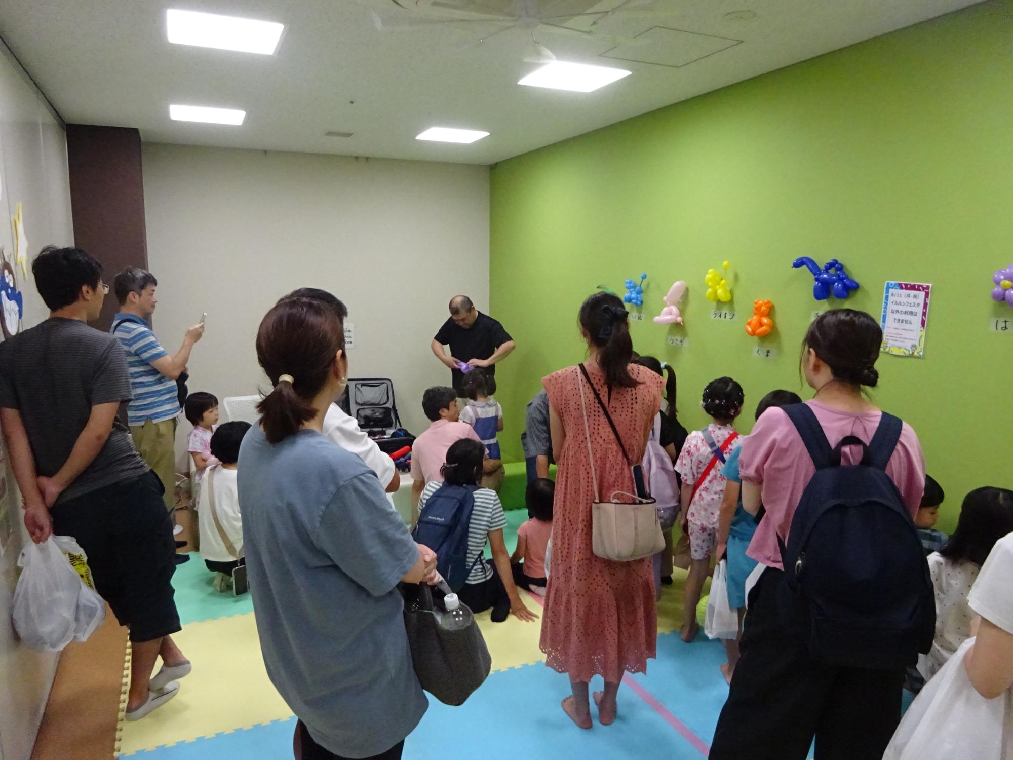 無料バルーンアートを作っている様子を見ている来場者の写真