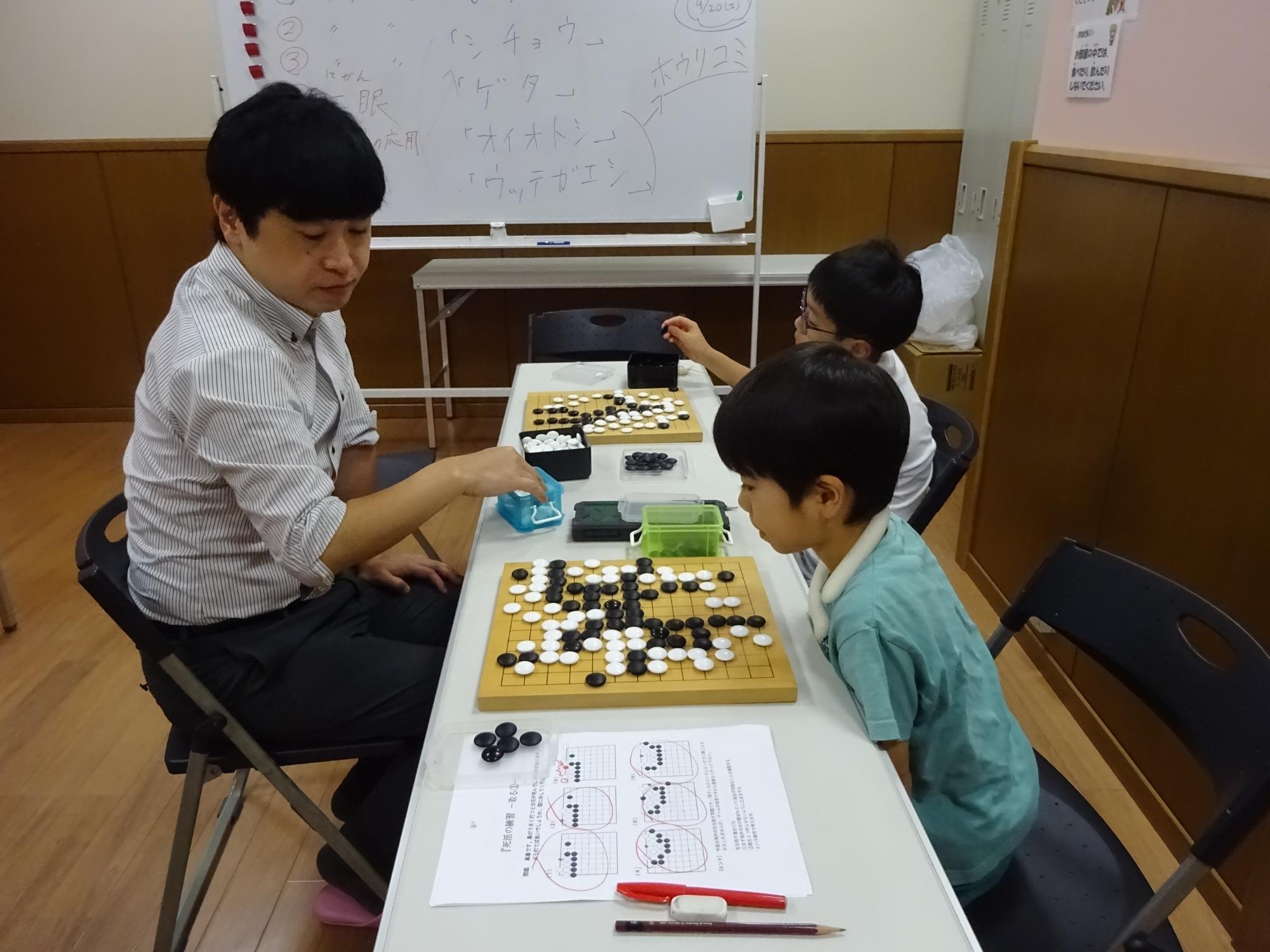 先生と対戦している子どもたちの写真