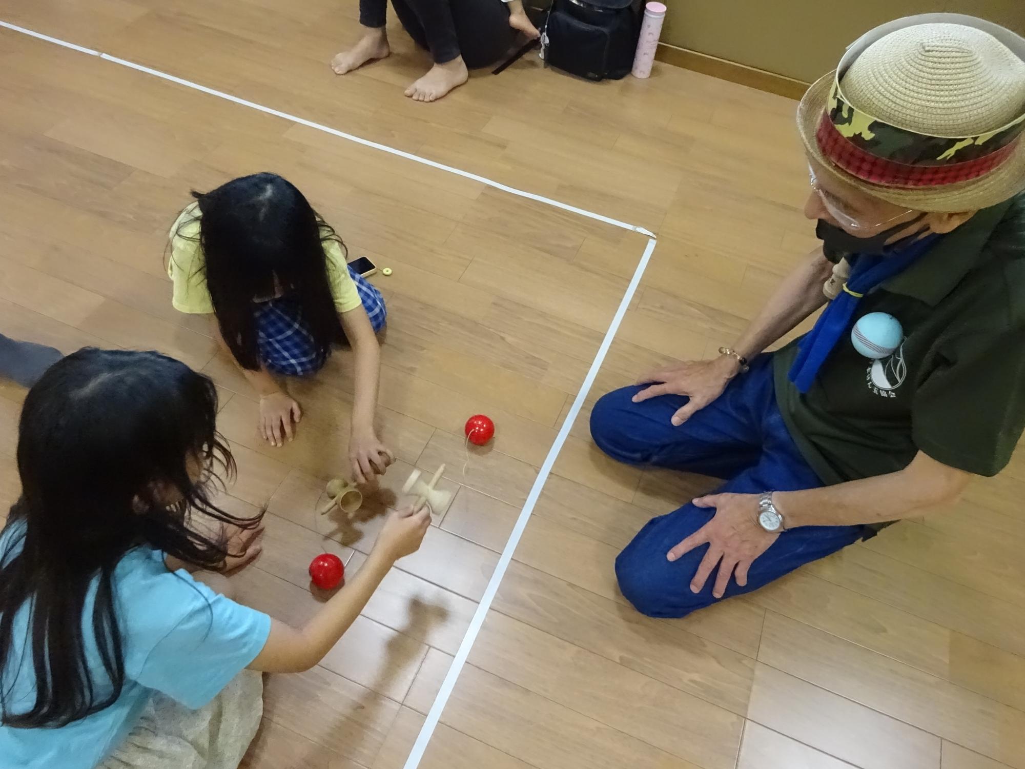 けん玉を使った遊びを楽しむ子どもたちの写真