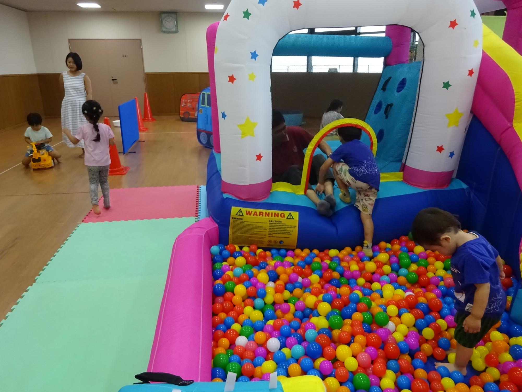 大型遊具で遊ぶ幼児親子の写真1