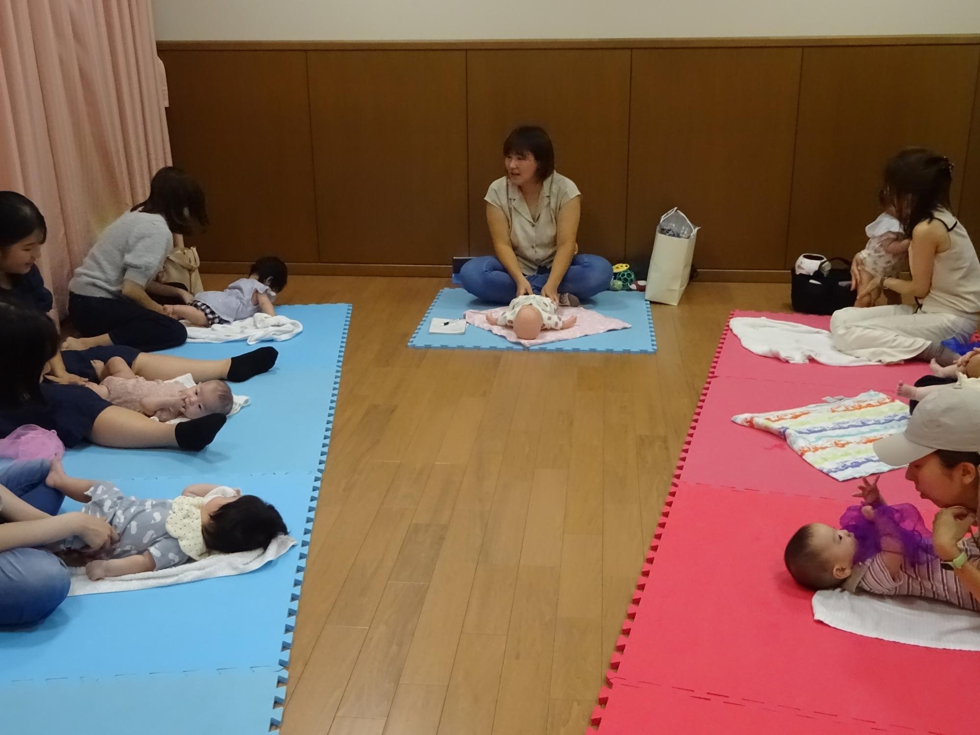 マットの上でベビーマッサージをしている様子の写真2