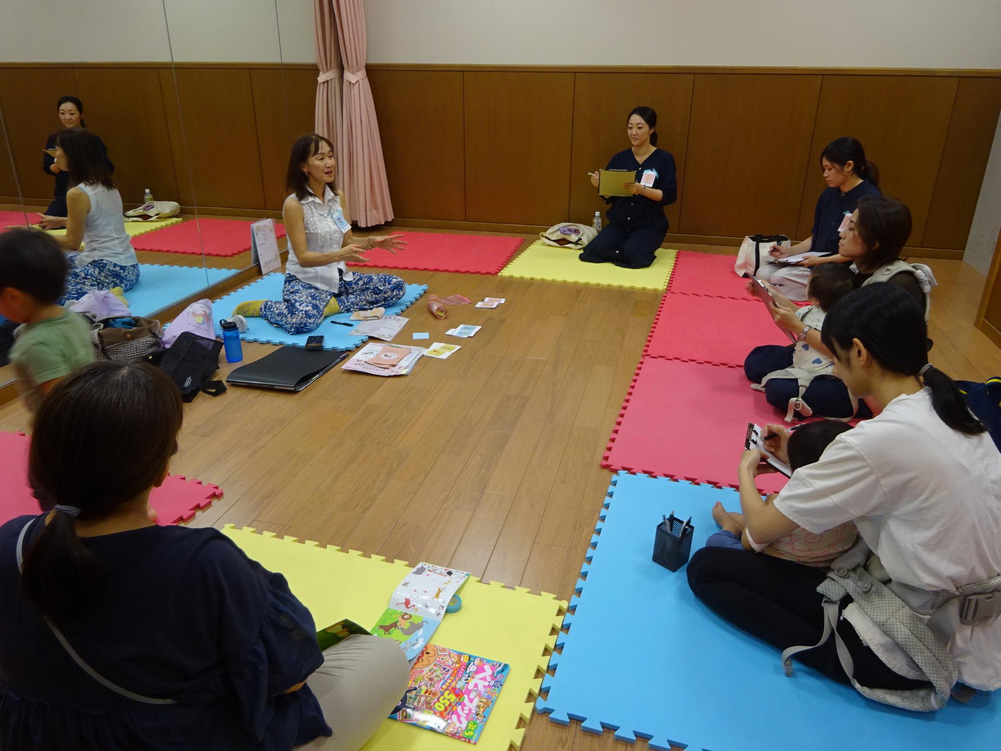 個性について説明している講師とそれを聞いている5組の親子の写真。