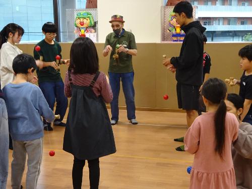 小学生や中学生がけん玉の練習をしている写真
