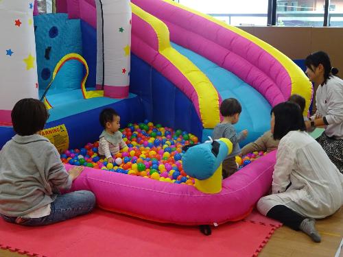 大型遊具のボールプールで遊んでいる乳幼児親子たちの写真