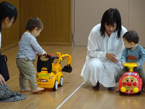 コンビカーに乗って遊ぶ二組の幼児親子の写真