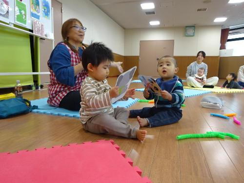 カラフルなマットの上で遊ぶ幼児たちの写真