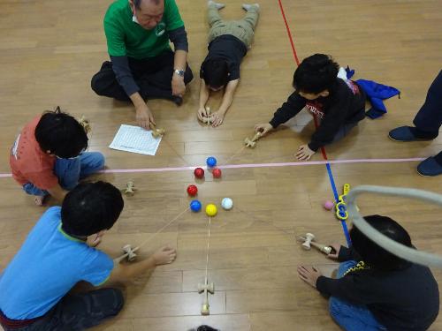 カラフルなけん玉を使ったゲームをしている子どもたちの写真
