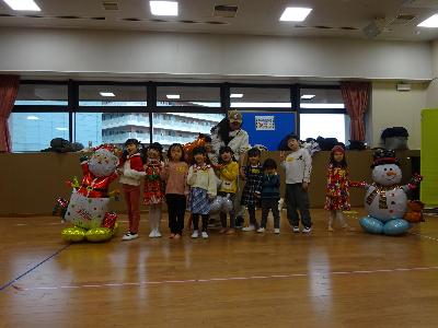 講師と参加児童と雪だるまとサンタクロースのバルーン装飾の集合写真