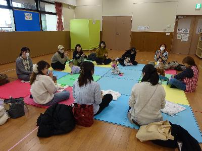カラフルなマットの上で自己紹介をする幼児親子たちの写真