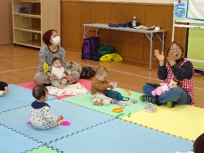 カラフルなマットの上で遊ぶ幼児たちの写真