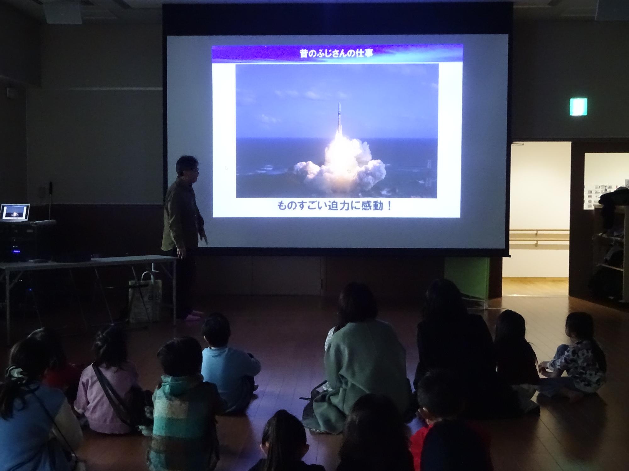 発射したロケットの画像について説明している講師と参加者の写真