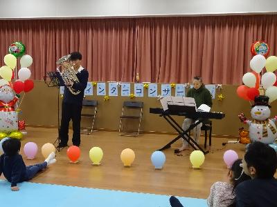 ユーフォニウムを演奏している高校生とピアノを弾いている成人の写真