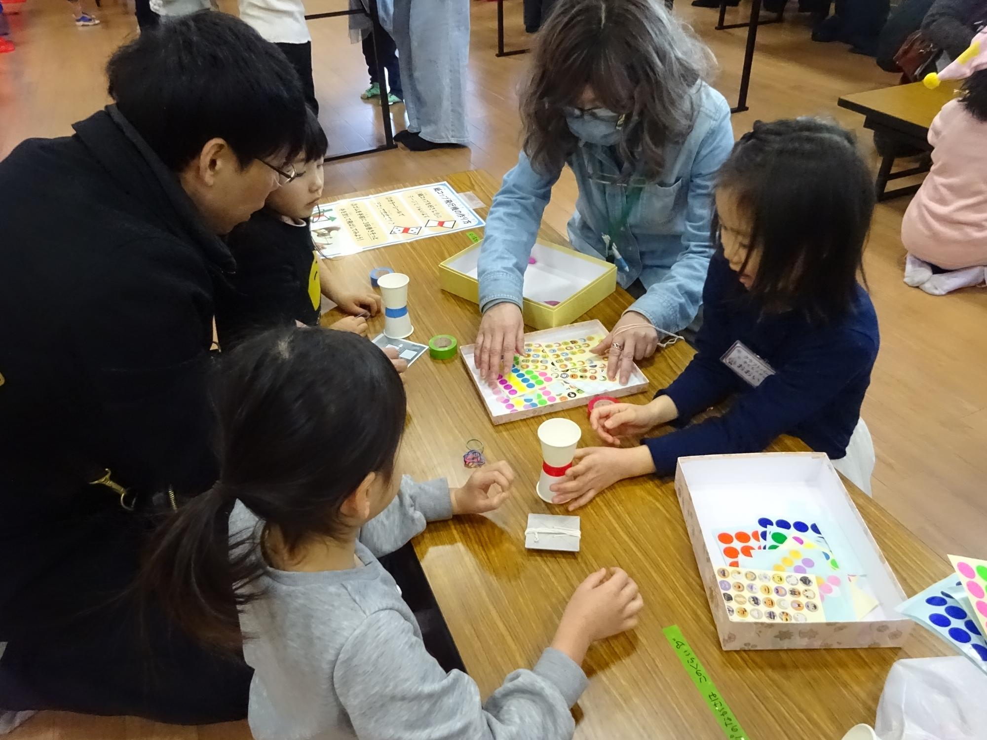 こどもスタッフが参加者に工作を教えている様子