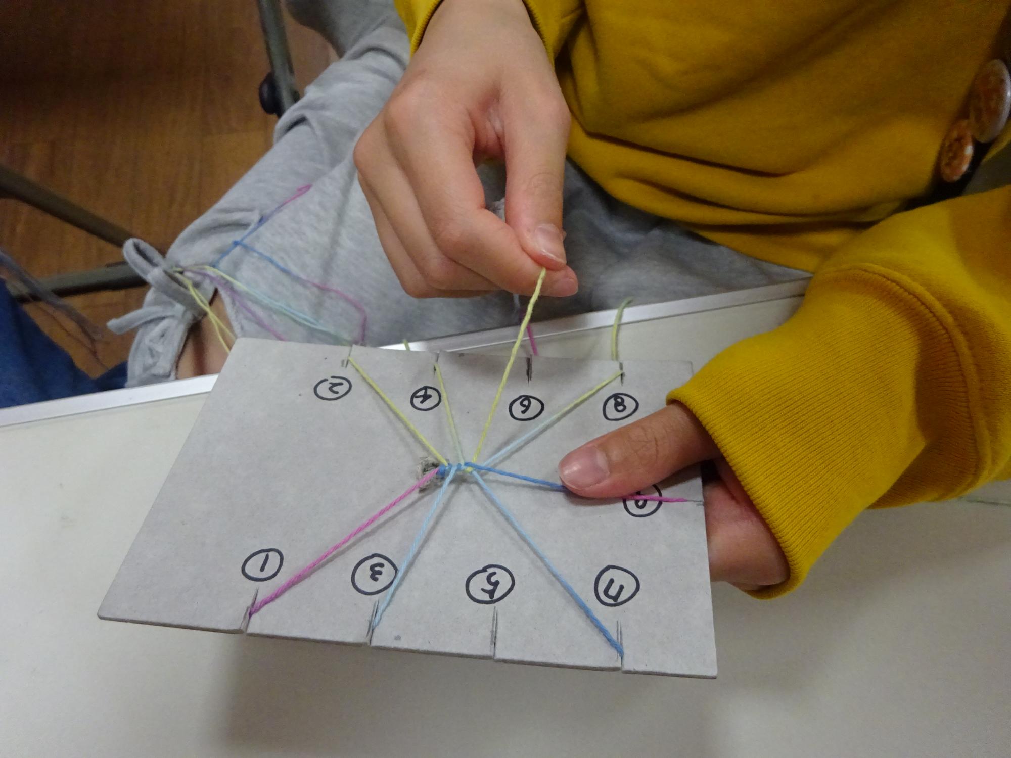 糸でミサンガを編んでいる様子