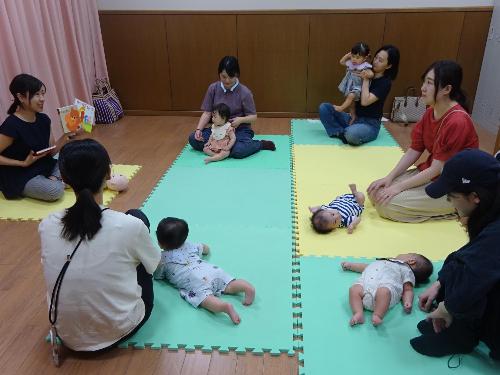 絵本の読み聞かせを聞いている幼児親子たちの写真