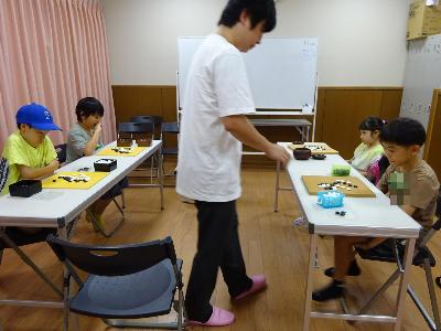 講師と対局をしている子どもたちの写真