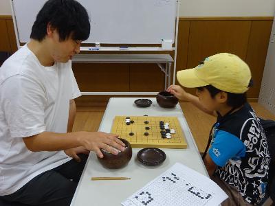 先生と対局している子どもの写真